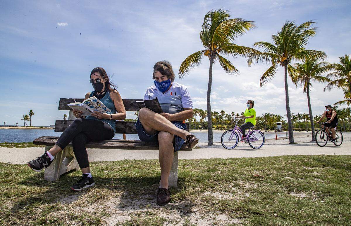 Barbara and Gary Keisberg take time to read their books while visiting Matheson Hammock Park during a visit in 2020.