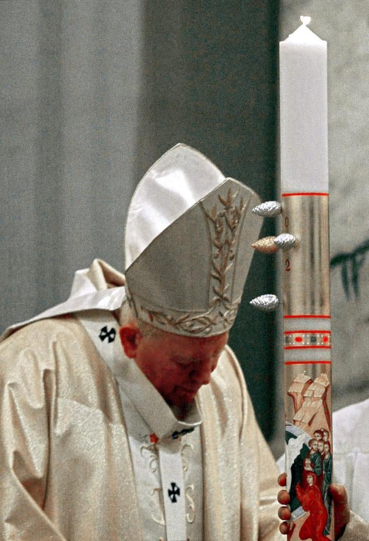 Pope John Paul II prays before the paschal candle that symbolizes the Light of Christ during Easter Vigil inside St. Peter's Basilica at the Vatican Saturday, March 30, 2002. The pontiff marked the approach of Easter on Saturday with a candlelight vigil in St. Peter's, the most solemn ceremony in the Catholic calendar.