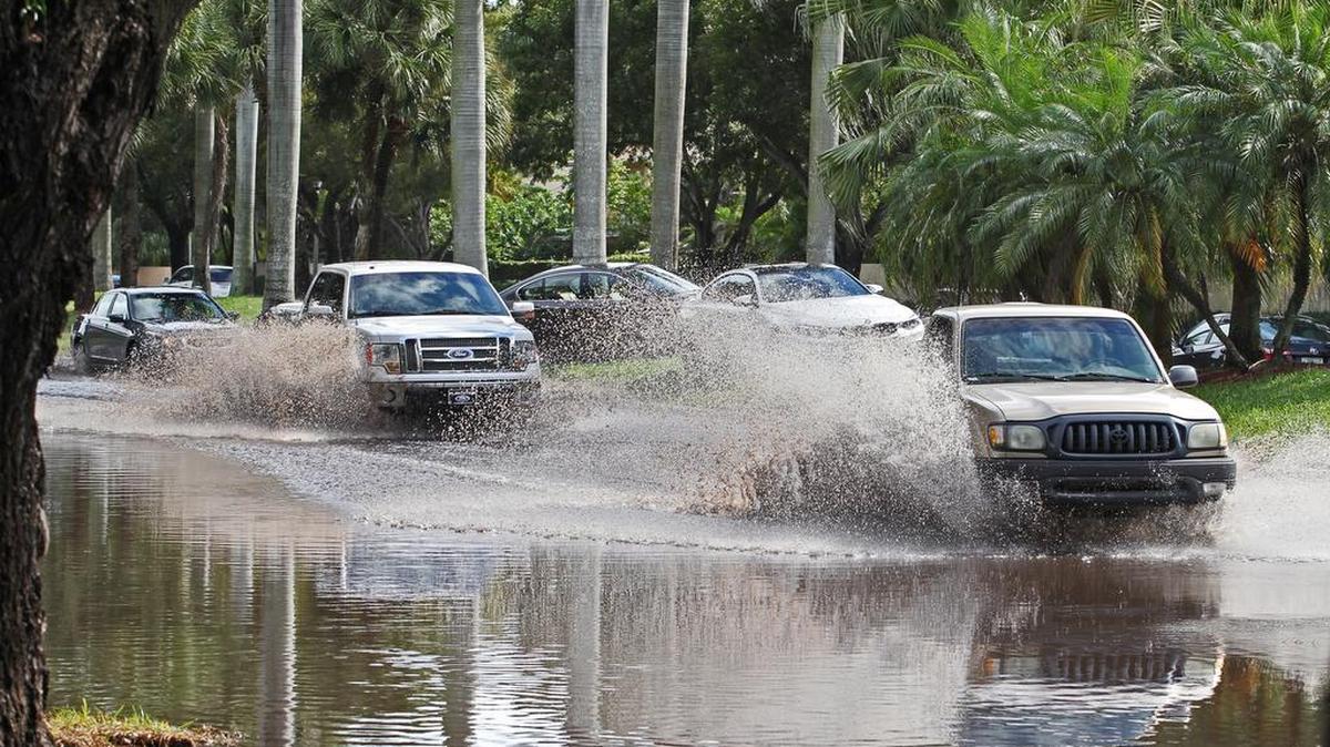 Westbound drivers on Sunday carefully navigate flooding on Southwest 104th Street near 147th Avenue in West Kendall as they pass stranded vehicles on the median on Sunday after a weekend inundated with rain.