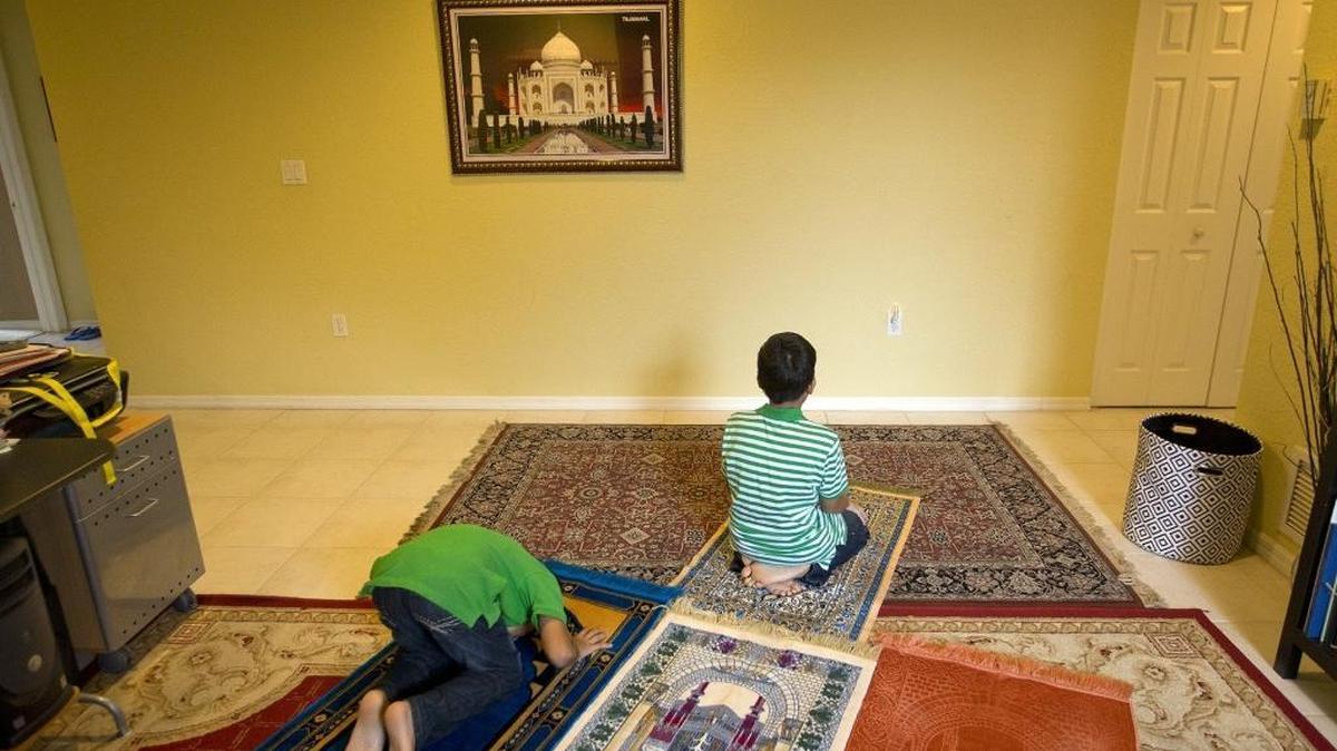 In this file photo, brothers Dayaan Shah 10, and Amaan Shah 11, pray at home on Wednesday, July 15, 2015. The young men have taken part in their first month-long fast of Ramadan. This coming Friday is the Eid al-Fitr , which marks the end of the month-long fast of Ramadan.