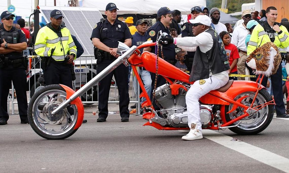 A motorcyclist passes by a group of police officers during the 41st Annual Martin Luther King Jr. Day Parade in Liberty City as it made its way west toward 27th Avenue in the 1700 block of Northwest 54th Street, Miami, on Monday, Jan. 15, 2018.