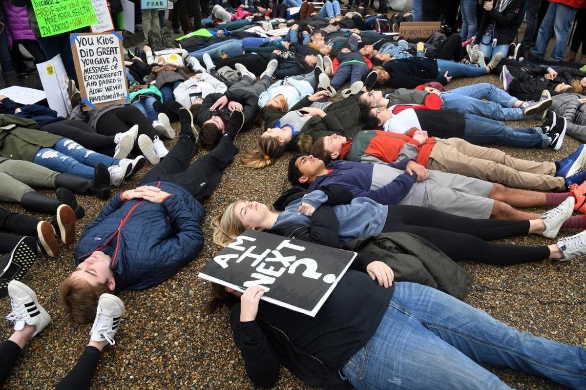 Students take part in a “lie-in” on the road outside the White House on Monday in Washington, D.C., for three minutes at a time in an effort to symbolize the short amount of time it took Nikolas Cruz to gun down students and teachers at Marjory Stoneman Douglas High School in Parkland.