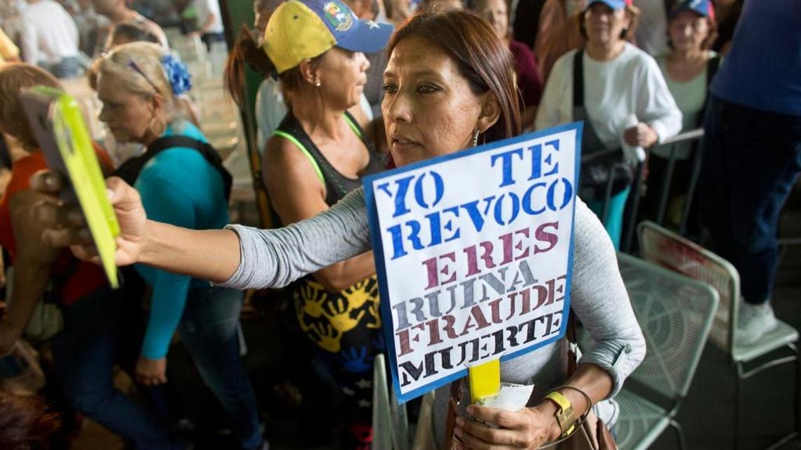 A woman participates in a demonstration in Caracas on April 19, with a sign bearing a message for the ruling Nicolas Maduro.