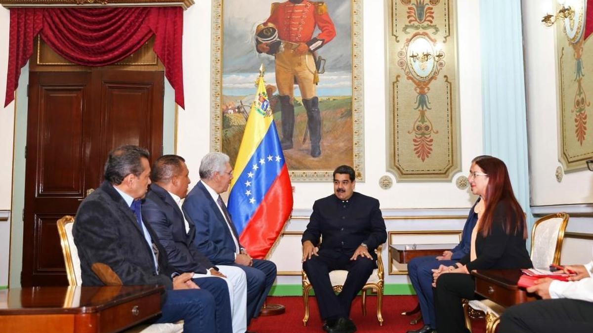 In this photo released by Miraflores presidential palace, Venezuela's President Nicolas Maduro, center, talks to opposition governors, from left, Antonio Barreto of Anzoategui state, Alfredo Diaz of Nueva Esparta state and Ramon Guevara of Merida state in Caracas, Venezuela, Tuesday, Oct. 24, 2017.