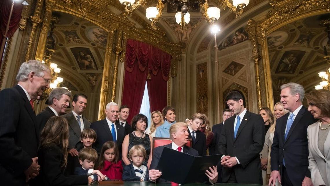 President Donald Trump turns to House Speaker Paul Ryan as he is joined by the Congressional leadership and his family as he formally signs his cabinet nominations into law, in the President's Room of the Senate, at the Capitol in Washington, Friday, Jan. 20, 2017.