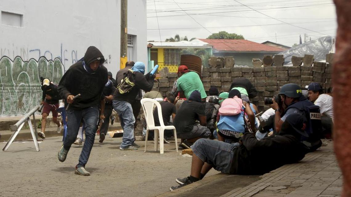 Opponents to the government of Nicaraguan President Daniel Ortega confront government forces at a barricade as they enter the city of Masaya, Nicaragua, Tuesday, June 19, 2018.