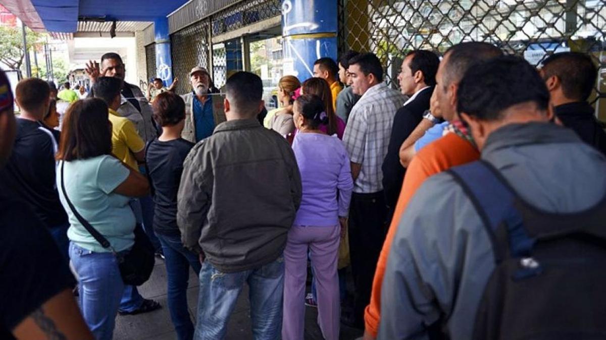 Venezuelans wait on a long line outside a store when its hours of operation were shortened in 2016.