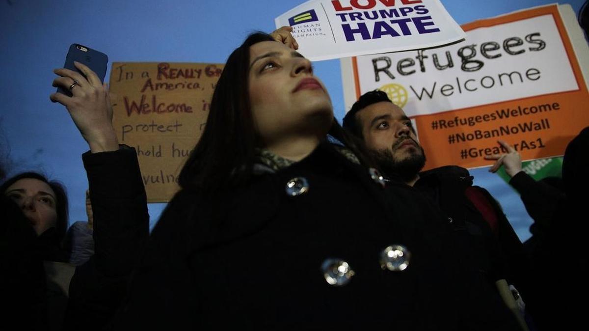 Activists hold signs during a protest outside the White House March 6, 2017, in Washington, D.C. Activists staged a protest against President Donald Trump's second Executive Order banning travel from certain muslim-majority countries.