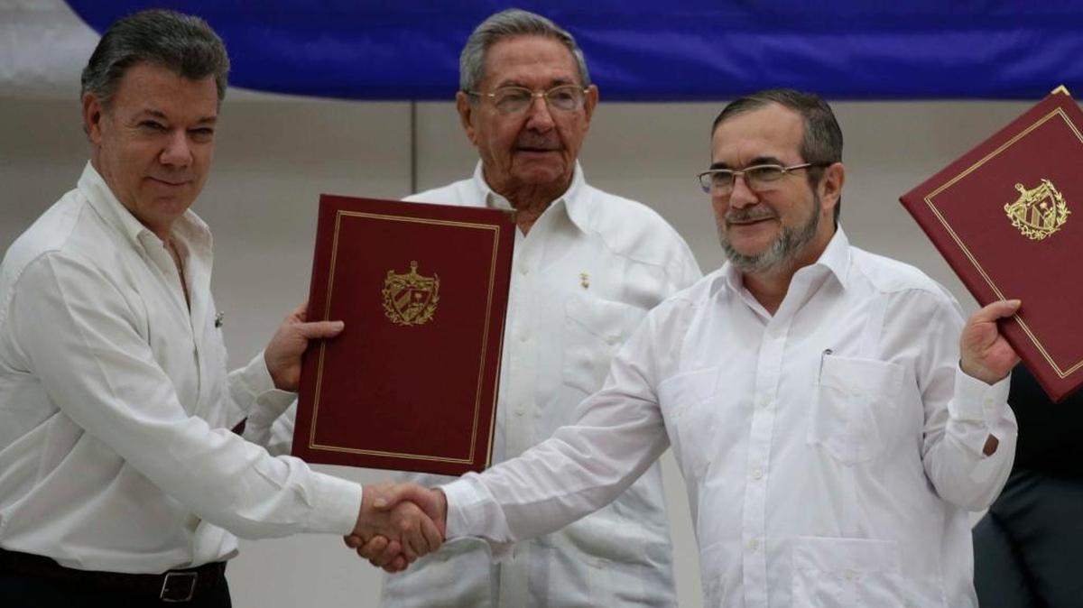 Colombian President Juan Manuel Santos, left, Cuba's President Raul Castro, center, and Commander of the Revolutionary Armed Forces of Colombia or FARC, Timoleon Jimenez, pose for photos during a signing ceremony of a cease-fire and rebel disarmament deal, in Havana, Cuba, Thursday.