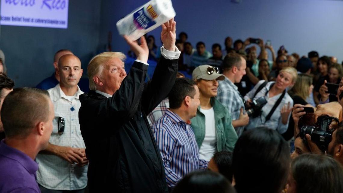 President Donald Trump tosses paper towels into a crowd as he hands out supplies at Calvary Chapel, Tuesday, Oct. 3, 2017, in Guaynabo, Puerto Rico. Trump is in Puerto Rico to survey hurricane damage.