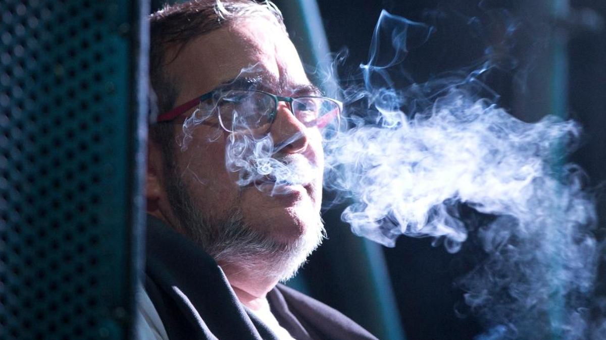 Rdrigo Londono, also known as Tmochenko, the top leader of the Revolutionary Armed Forces of Colombia, FARC, smokes as he watches from stage a concert performed by a rebel ensemble during the 10th conference of the Revolutionary Armed Forces of Colombia, FARC, in the Yari Plains, southern Colombia, Sunday, Sept. 18, 2016.