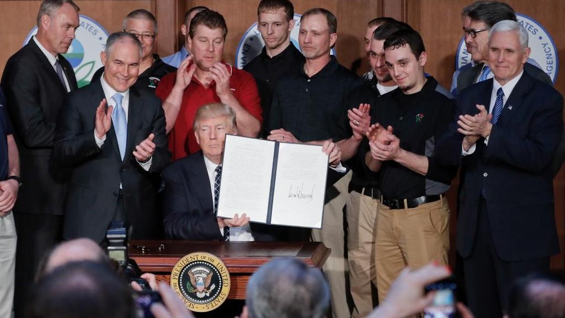 President Donald Trump, accompanied by coal miners and, from left, Interior Secretary Ryan Zinke, Environmental Protection Agency (EPA) Administrator Scott Pruitt, second from right, Energy Secretary Rick Perry, and Vice President Mike Pence, far right.
