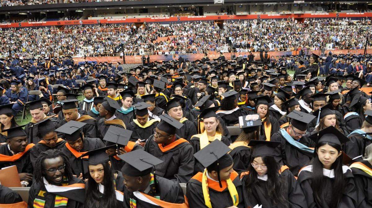 IMAGE DISTRIBUTED FOR SYRACUSE UNIVERSITY - Graduates settle in before the start of Syracuse University 159th Commencement ceremony in Syracuse, N.Y., Sunday, May 12, 2013. (Kevin Rivoli / AP Images for Syracuse University)