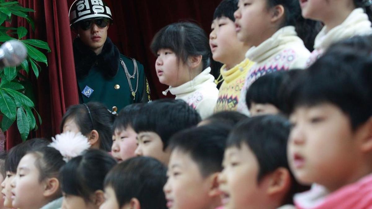 Students of Taesungdong Elementary School sing during a graduation ceremony as an army soldier stands guard near the border village of Panmunjom in Paju, South Korea, Friday, Feb. 14, 2014. Taesungdong is the only South Korean village sitting inside the demilitarized zone between North and South Korea.