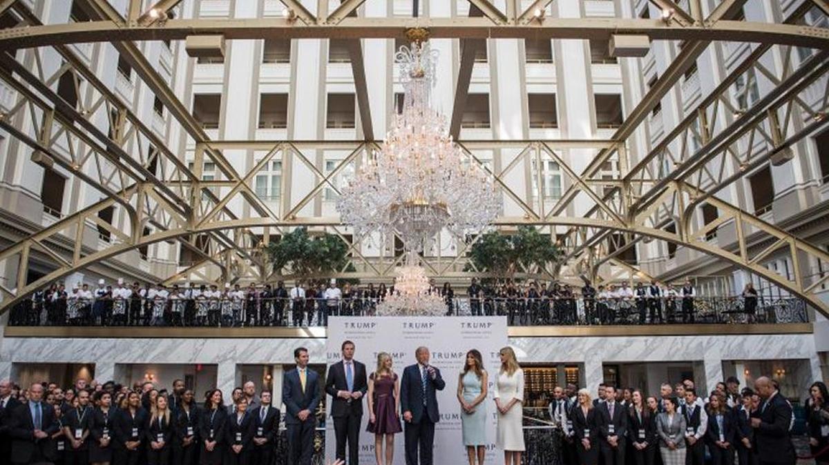 In October 2016, while still a presidential candidate, Donald Trump, with his family, prepared to cut a ribbon during the grand opening ceremony of the Trump International Hotel in Washington, D.C.