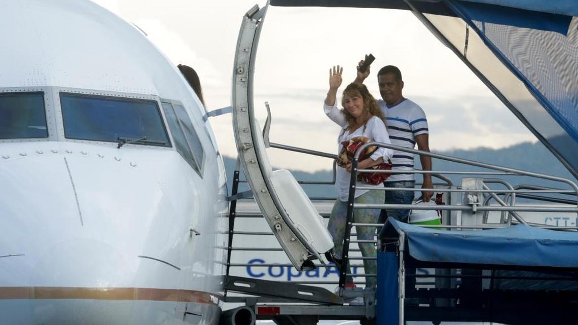 Two Cuban migrants wave as they board a chartered flight, in Panama City on May 10, 2016. Panama closed its border to Cuban immigrants trying to make their way north to the United States but agreed to fly already arrived Cubans, each responsible for their own airfare, to the Mexican border town of Ciudad Juarez. From there, they are expected to enter the U.S.