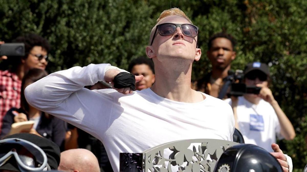 A man makes a slashing motion across his throat toward counter-protesters as he marches in white supremacists’ “Unite the Right” rally in Charlottesville, Virginia, last year.