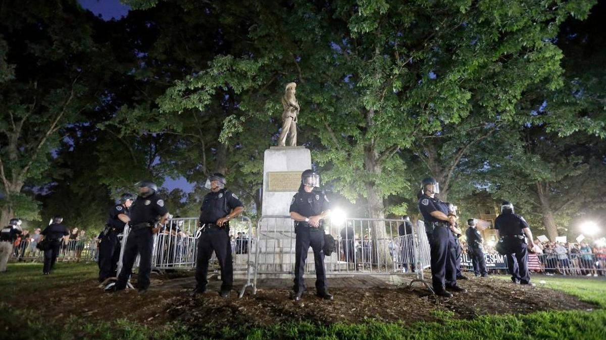 Police surround a Confederate monument during a protest to remove the statue at the University of North Carolina in Chapel Hill, N.C., Tuesday, Aug. 22, 2017.