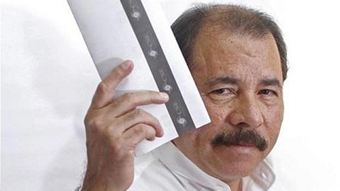 Daniel Ortega shows off his ballot before casting a vote. A compliant National Assembly eliminated term limits, allowing him to run for a third term.