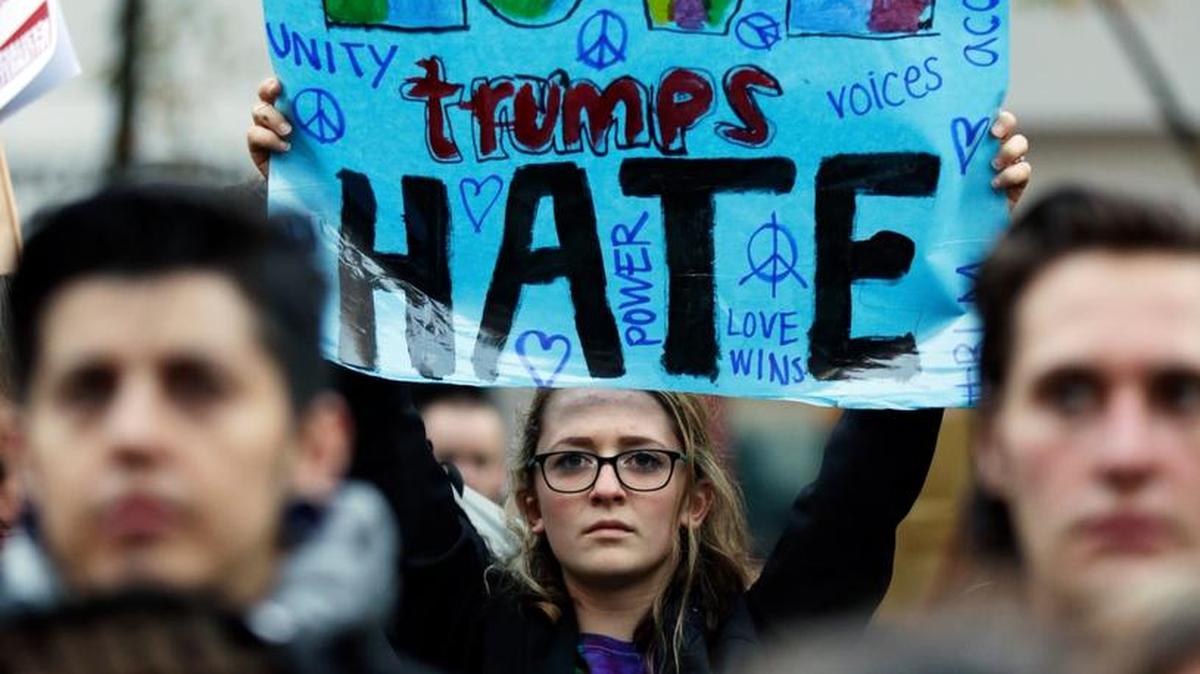 A protester holds a sign that reads "Love Trumps Hate" during a protest against the election of President-elect Donald Trump, Wednesday, Nov. 9, 2016 in downtown Seattle.