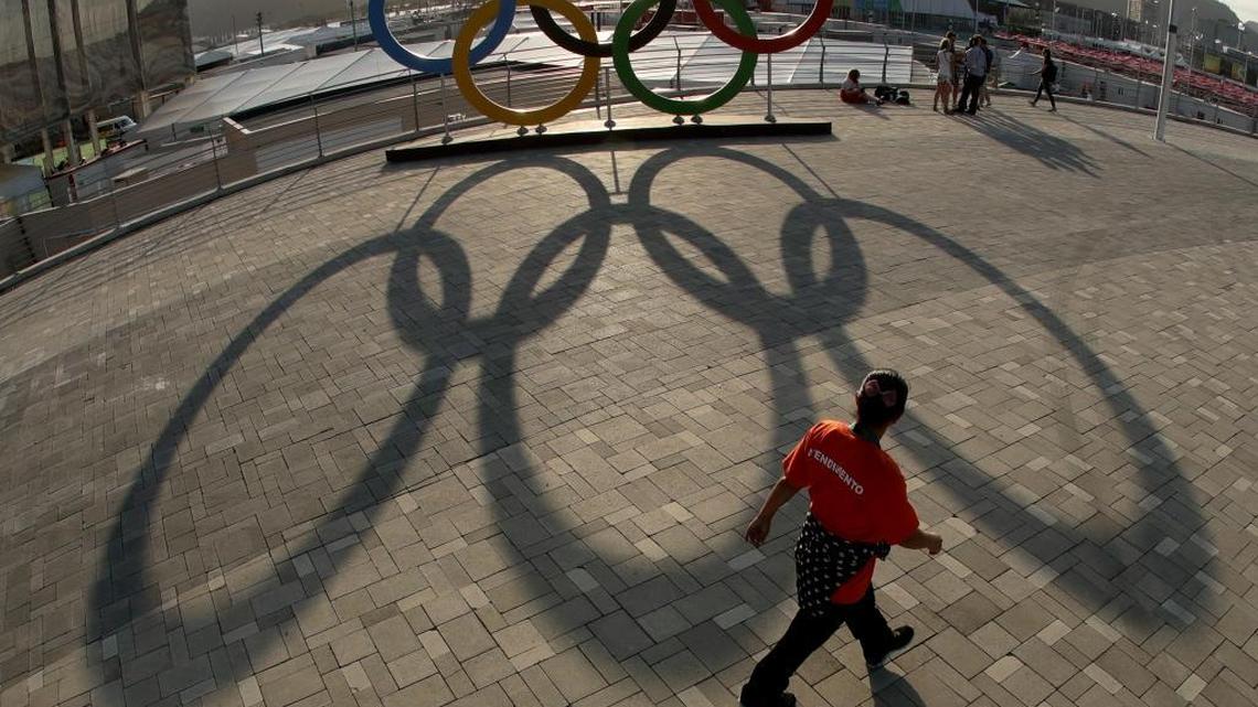 A worker walks past a set of Olympic rings in the Olympic Park ahead of the Rio 2016 Summer Olympics, in Rio de Janeiro, Brazil.