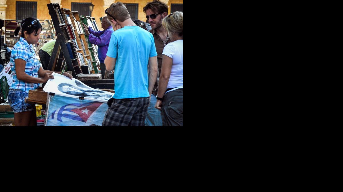
Tourists look at posters for sale in Havana, on December 18, 2014. A series of measures that US President Barck Obama announced could boost economic exchanges as the United States and Cuba move to restore diplomatic relations.
