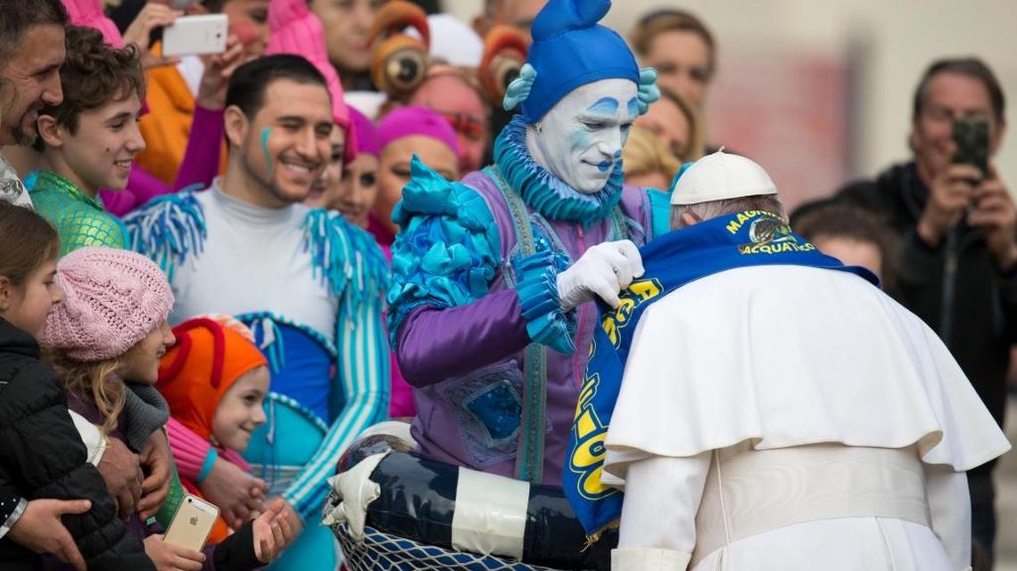 Circus artists who performed for Pope Francis during his weekly general audience give him a scarf of their circus, in St. Peter's Square, at the Vatican on Wednesday.