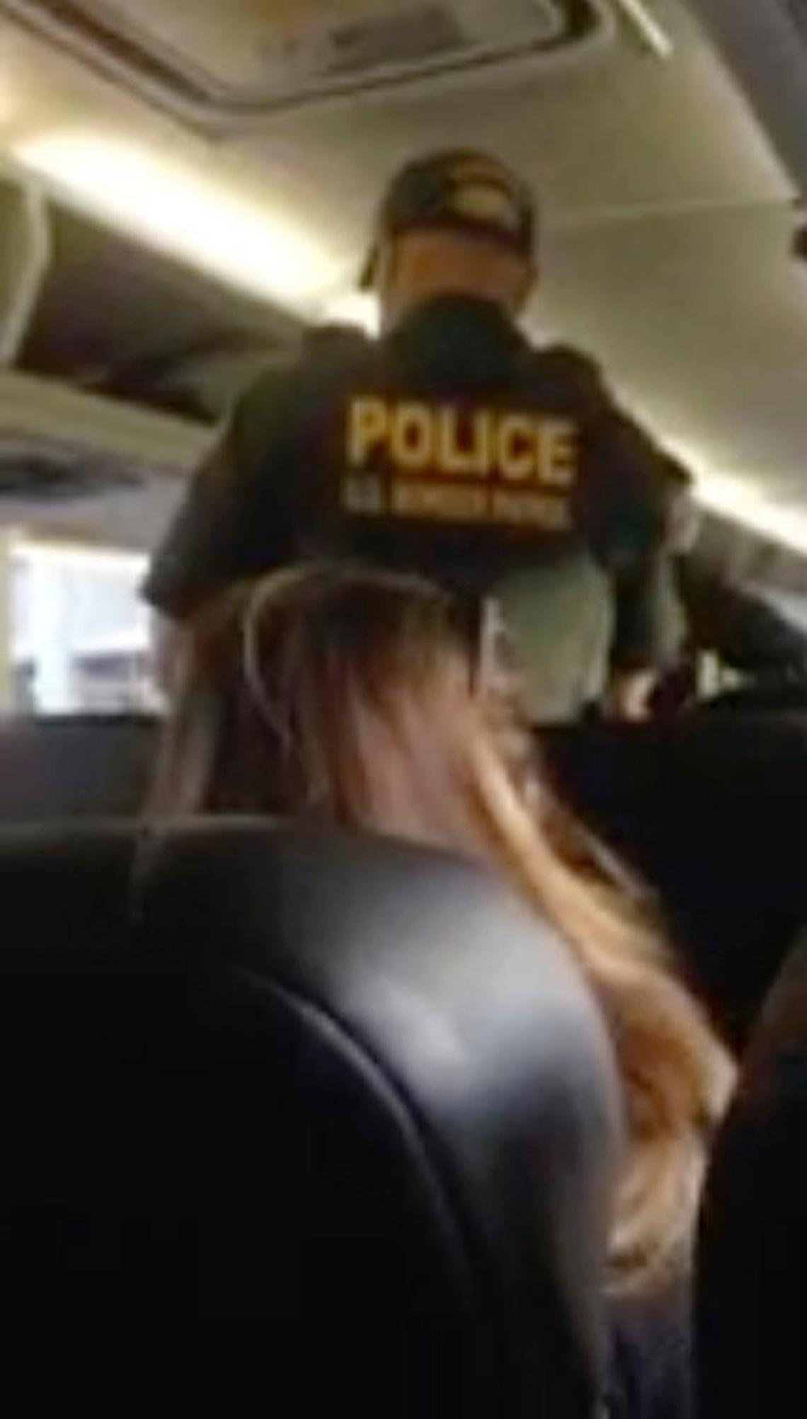 In this image made from video, a Border Patrol officer requests identification of travelers on a Greyhound bus in Fort Lauderdale. The agents escorted a Jamaican woman off the bus.
