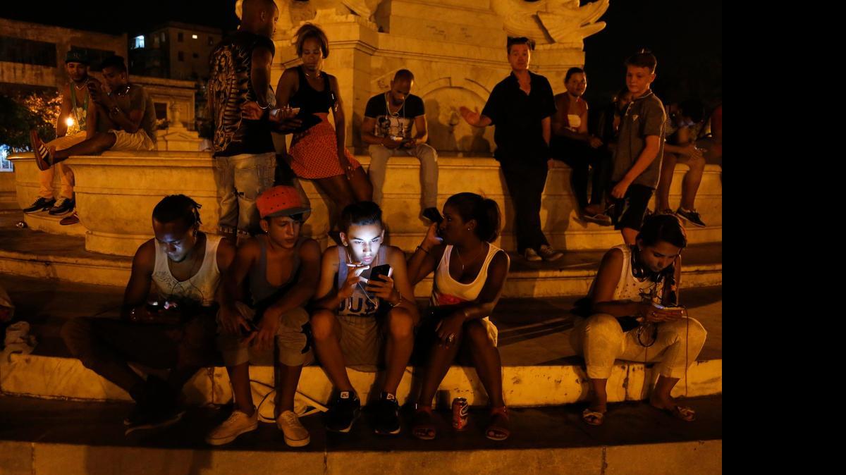 
Young Cubans use their smart phones to surf the Internet, using a password protected wifi network coming from a five star hotel in downtown Havana.
