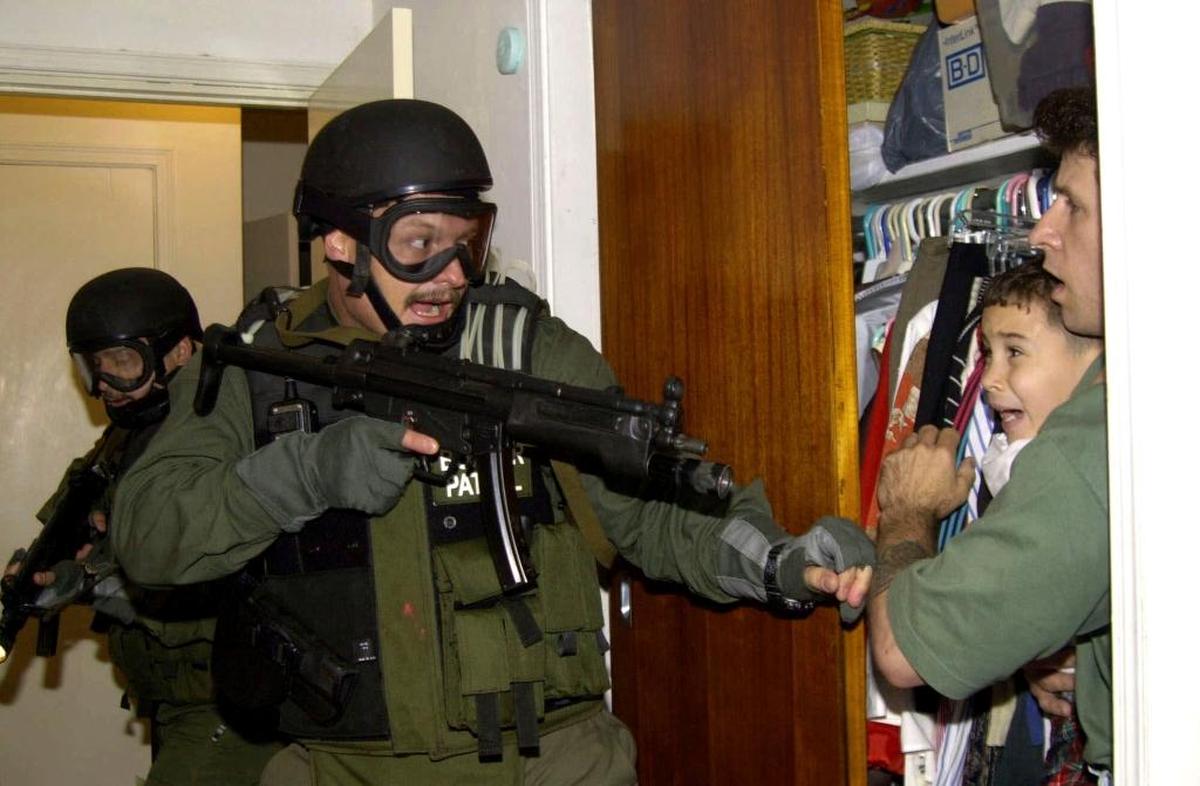 In this April 22, 2000, file photo, Elian Gonzalez is held in a closet by Donato Dalrymple, right, as government officials search the home of Lazaro Gonzalez for the young boy in Miami. U.S.-based relatives fought to keep Gonzalez, rescued at sea at age 5 after his mother died, but U.S. officials finally sent him back to his father in Cuba. ‘Elian,’ a film about the boy, premiered at the Tribeca Film Festival.