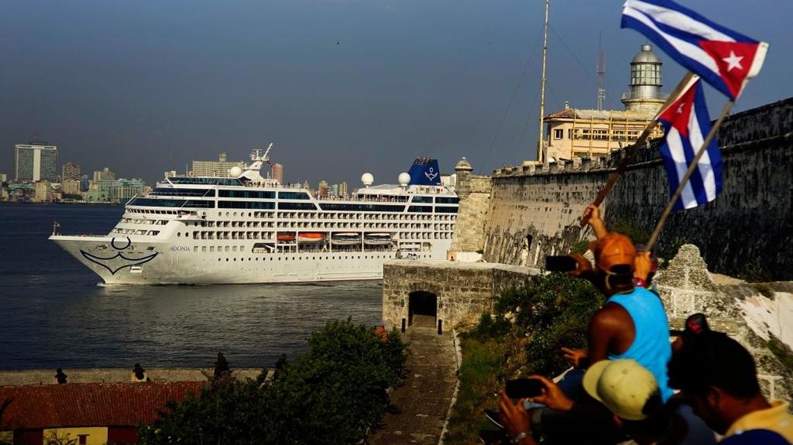 In this May 2, 2016 photo, people waving Cuban flags greet passengers on Carnival's Adonia cruise ship as they arrive from Miami in Havana, Cuba.