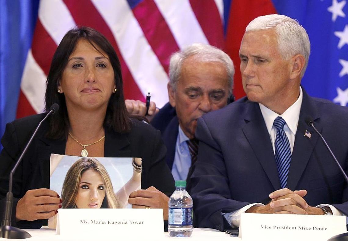 Venezuelan exile Maria Eugenia Tovar holds a photo of her daughter, who was killed in 2014, as Vice President Mike Pence, right, listens through a translator. Pence held a roundtable with many Venezuelan exiles at Our Lady of Guadalupe Catholic Church in Doral on Wednesday.