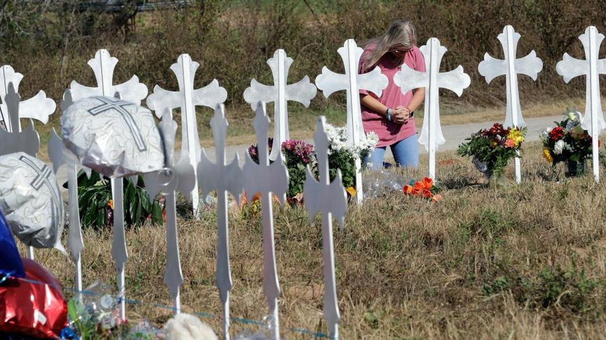 A woman kneels in prayer at a makeshift memorial for the First Baptist Church shooting victims Tuesday, Nov. 7, 2017, in Sutherland Springs, Texas.