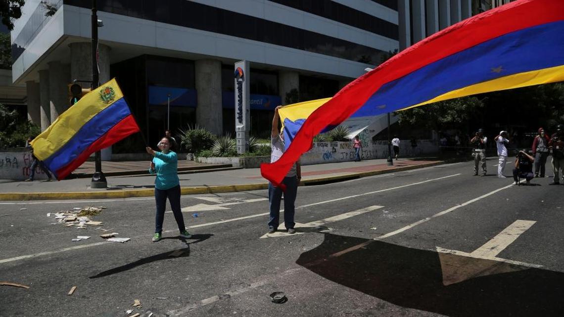 Anti-government demonstrators wave Venezuelan national flags during a protest against President Nicolas Maduro in Caracas on Tuesday, Aug. 8, 2017.