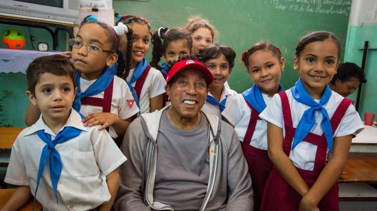 American artist Smokey Robinson poses for a picture with students of the Miguel Fernandez Roig primary school in Havana on Tuesday.