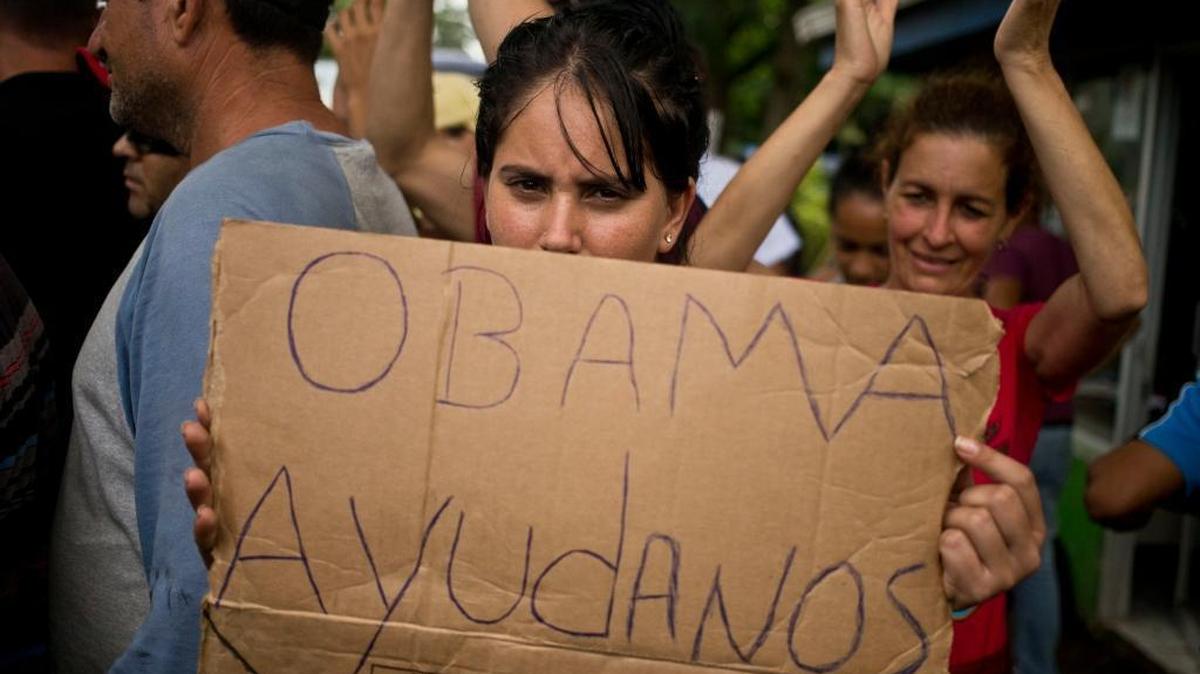 A Cuban migrant holds a sign that reads in Spanish “Help us Obama” during a protest at the Costa Rican border with Nicaragua on Monday.