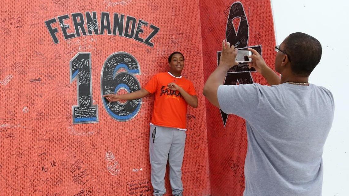 Davin Solomon poses next to the Jose Fernandez tribute as his dad Terrants Solomon takes his picture before the start Miami Marlins' home opener, against the Atlanta Braves, at Marlins Park on Tuesday.