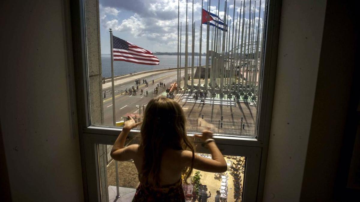 
A child looks out a window from inside the newly opened U.S. Embassy overlooking the staging area, at the end of a flag raising ceremony of the newly opened U.S. Embassy, in Havana, Cuba, Friday, Aug. 14, 2015. Washington's top diplomat traveled to the Cuban capital to raise the U.S. flag and formally reopen the long-closed U.S. Embassy. Cuba and U.S. officially restored diplomatic relations July 20. 
