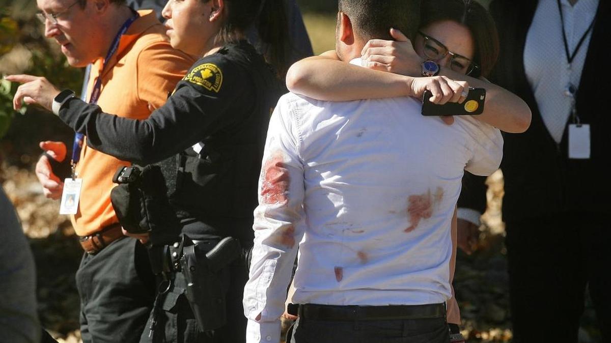 A couple embraces following the shooting rampage that killed at least 14 people and wounded others at Inland Regional Center in San Bernardino, California.