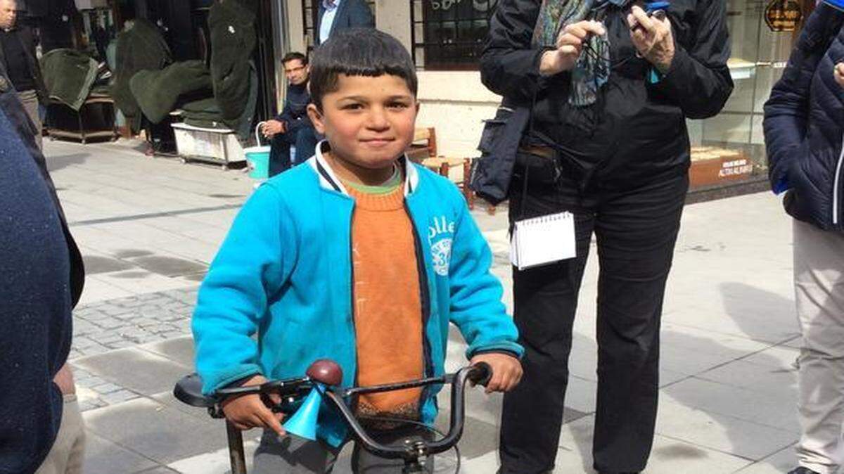 
Ibrahim, a 10-year-old Syrian boy and war refugee, shows off his prized bicycle to American tourists visiting Konya, Turkey.

