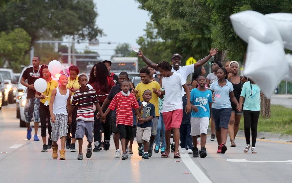 A group of families with their kids walked along Northwest 103rd Street during a peace walk in honor of 8-year-old Jada Page, who was killed in a driveby shooting.