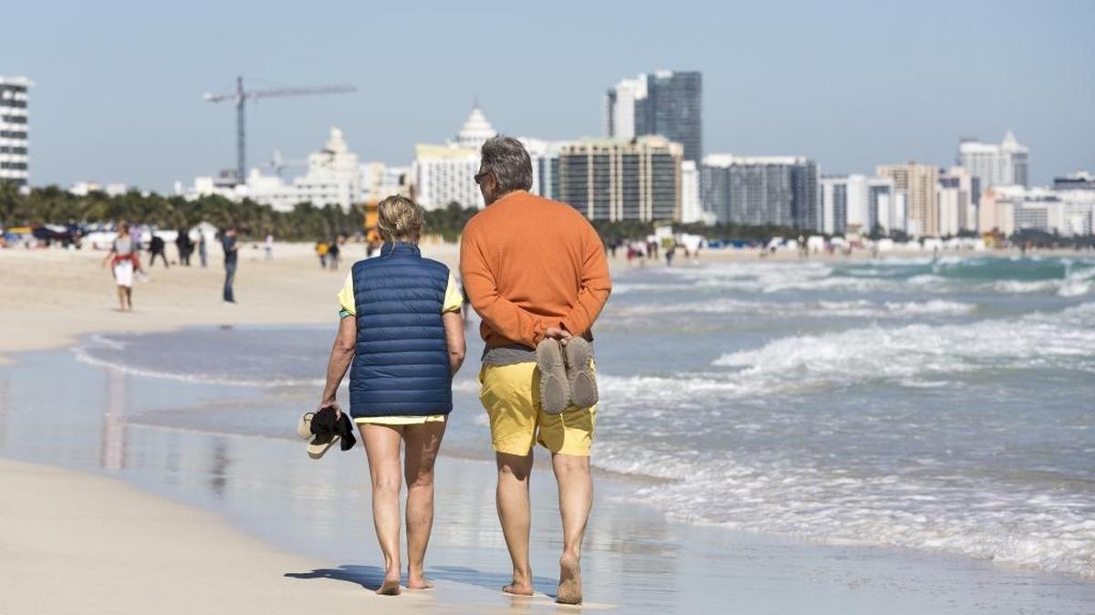 Miami Beach visitors walk the South Beach shoreline barefoot on Jan. 24, when a cold front hit Miami.