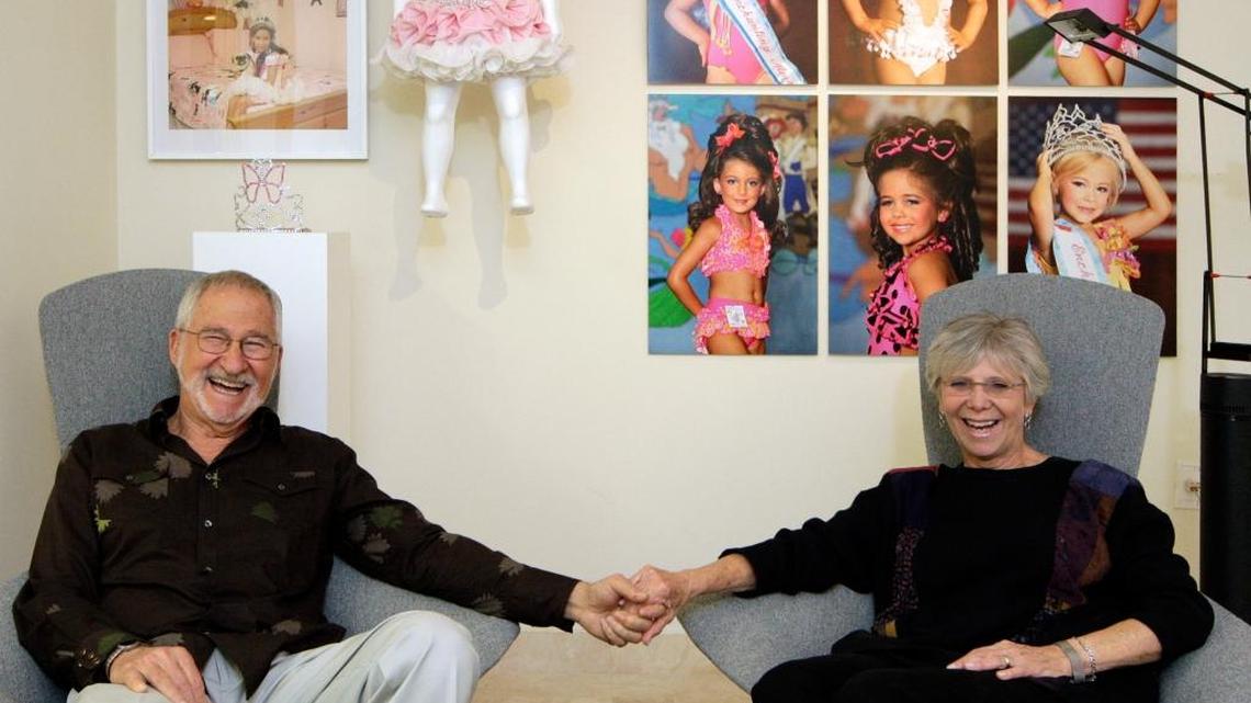Paul and Estelle Berg sit in their den/office with color photographs, crown and beauty pageant dress installation from Colby Katz's "Beauty Pageant" series in 2008.
