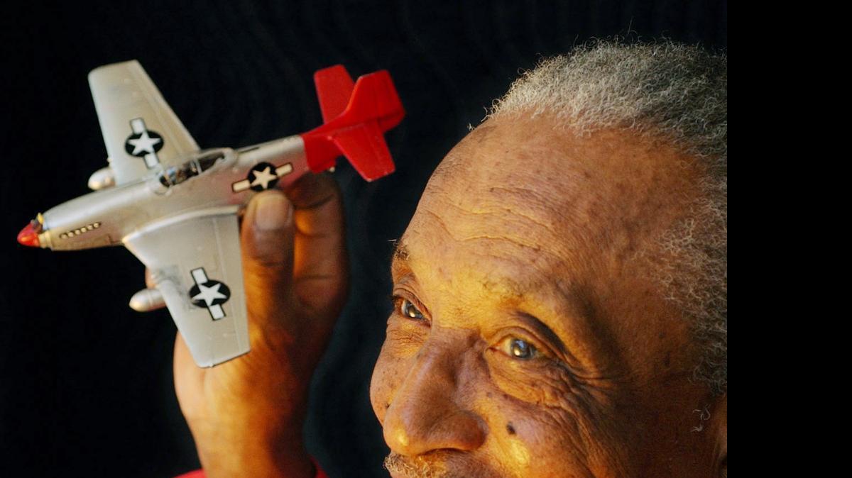 
TUSKEGEE AIRMEN HONOREE: Retired Air Force Lt. Col. Eldridge Williams, seen here in 2011, was one of the celebrated Tuskegee Airmen. He holds a model of a P-51 Mustang used in World War II. Williams was a fitness and survival trainer during the war, trained fellow black pilots in the Airmen, and in 1949 he became a fighter intercept controller. After the war he joined Dade County Public Schools and helped integrate Miami schools.
