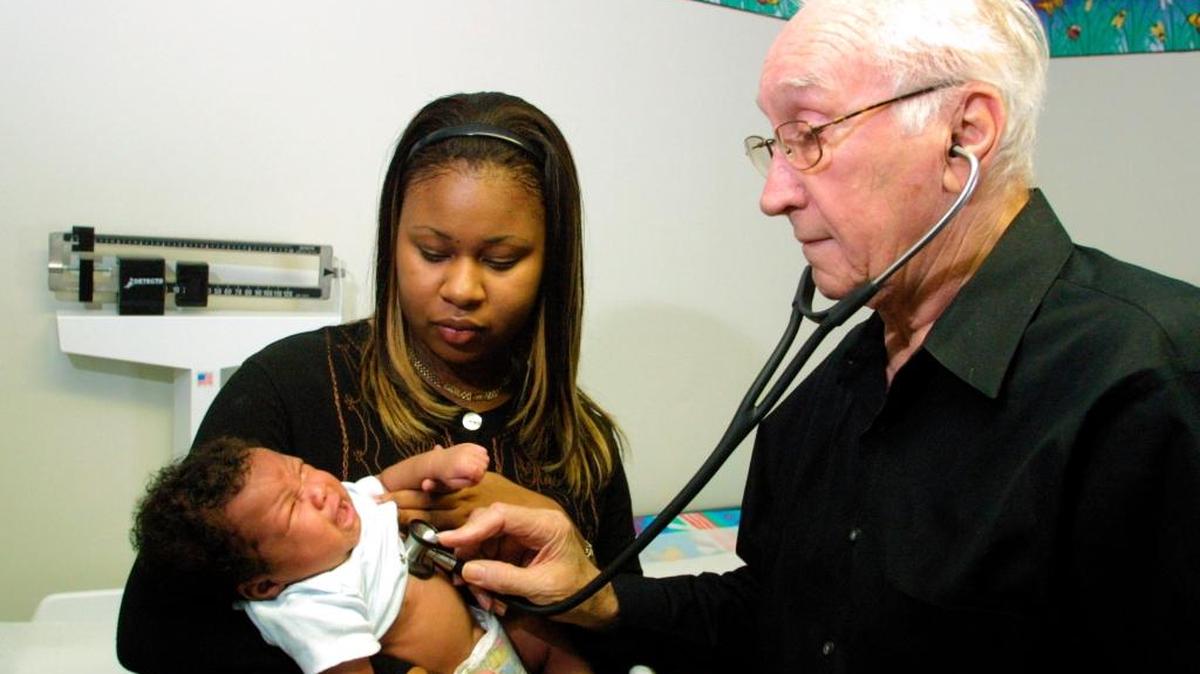 Dr. Norman Nash, in 2002, was still seeing some 2,500 patients at offices in Kendall, Hialeah and the Upper Keys. In this file photo, he examined Kahlil as mother Okima Lyons holds the baby.