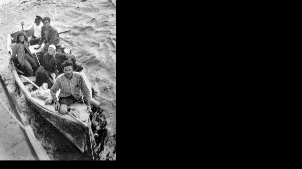 
EARLY RAFTER: Armando Rodriguez (front of boat), one of the first Cuban rafters in Florida, holds a rope thrown from the freighter Gulf Panther from Wilmington, Delaware, that rescued him and six others in the high seas as they escaped from Cuba in 1961. Rodriguez died at 96 in January 2014.
