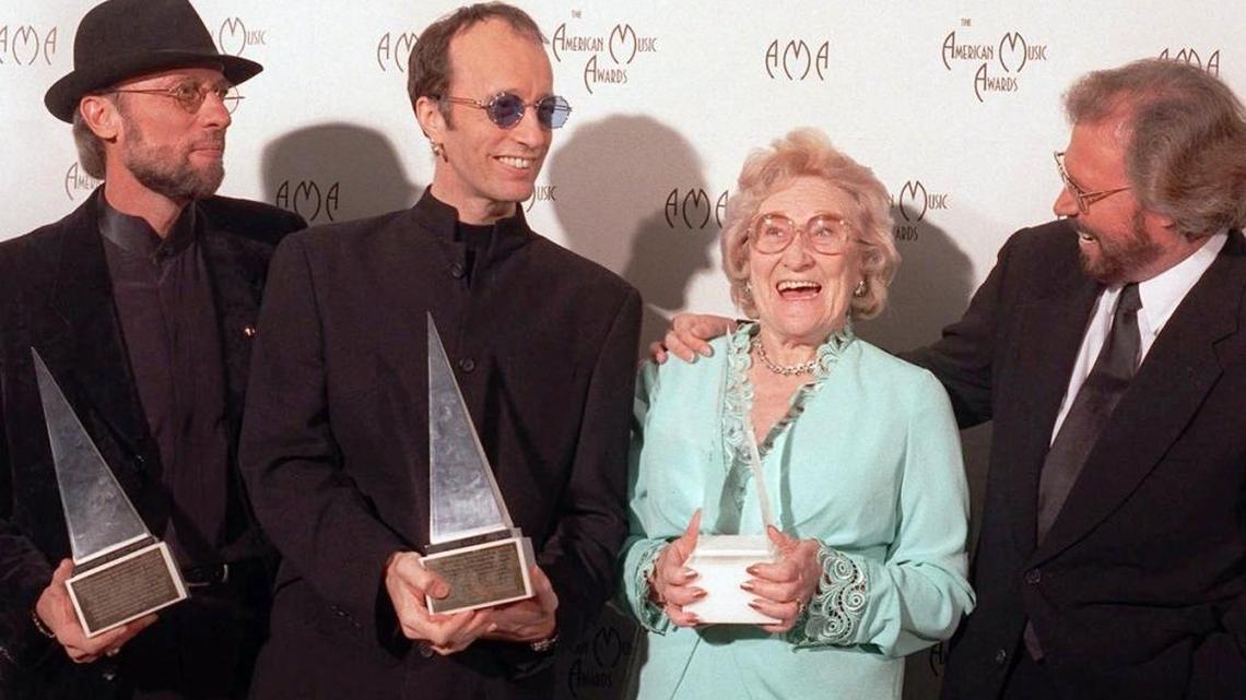 The Bee Gees share the honor of winning the 1997 International Award at the American Music Awards with their mom, Barbara Gibb. L-R: the late twins Maurice and Robin Gibb, Barbara Gibb, and eldest son, Barry Gibb.