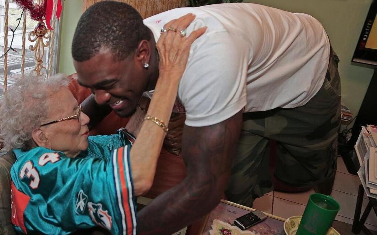 Willie Pearl Porter was the oldest living Dolphins fan in Miami when she met one of the players when she was 101. In this Dec. 11, 2012, photo, Porter, left, thanks Reshad Jones for the visit and the signed jersey. Dolphins safety Jones visited Porter and her family at their Liberty City home in Miami. Porter, who died at 105, had season tickets since the team’s inception in 1966.