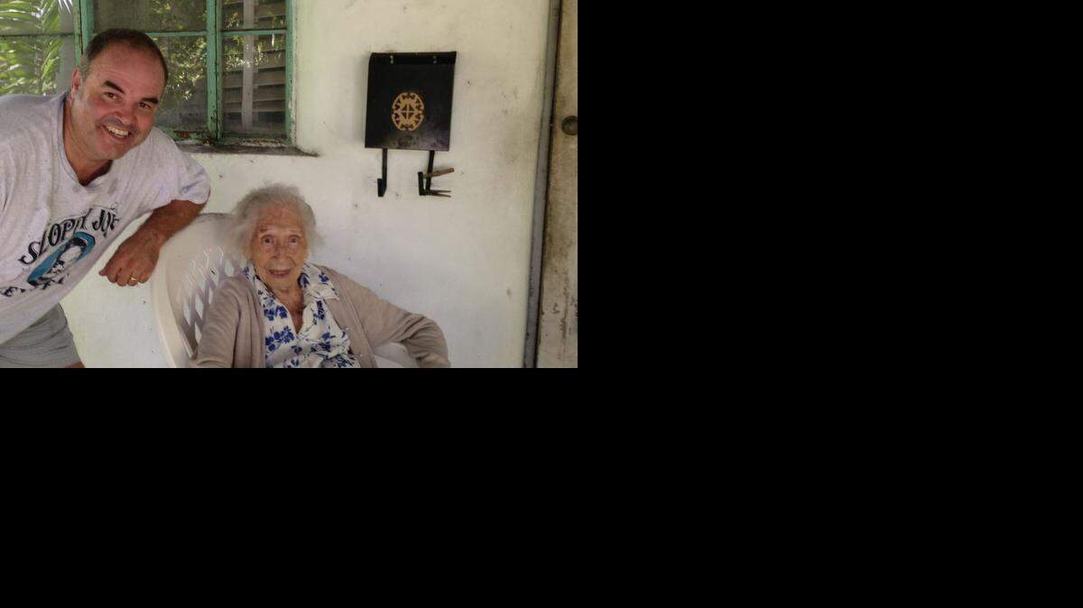 
CENTENARIAN: Anita Schuck, who wrote a line in her diary every day until she was 108, served witness to Miami from her porch in Miami’s Roads neighborhood. Here, Schuck is pictured at her home with friend, Miami artist Xavier Cortada. Schuck died at 111 in May.
