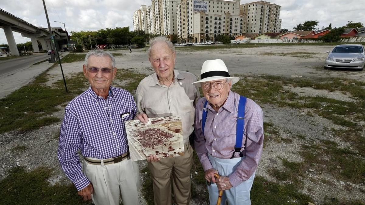 On May 14, 2015, for the 35th anniversary of the May 17, 1980, McDuffie riots, Howard Katzen (left), S. Ronald Pallot and Norton Pallot — family members who owned Norton Tire Co. — returned to the site of their Brownsville headquarters. The vacant lot was never rebuilt after rioters burned down their facility on the southwest corner of 54th Street and Northwest 27th Avenue. The photo in hand shows the destroyed building.